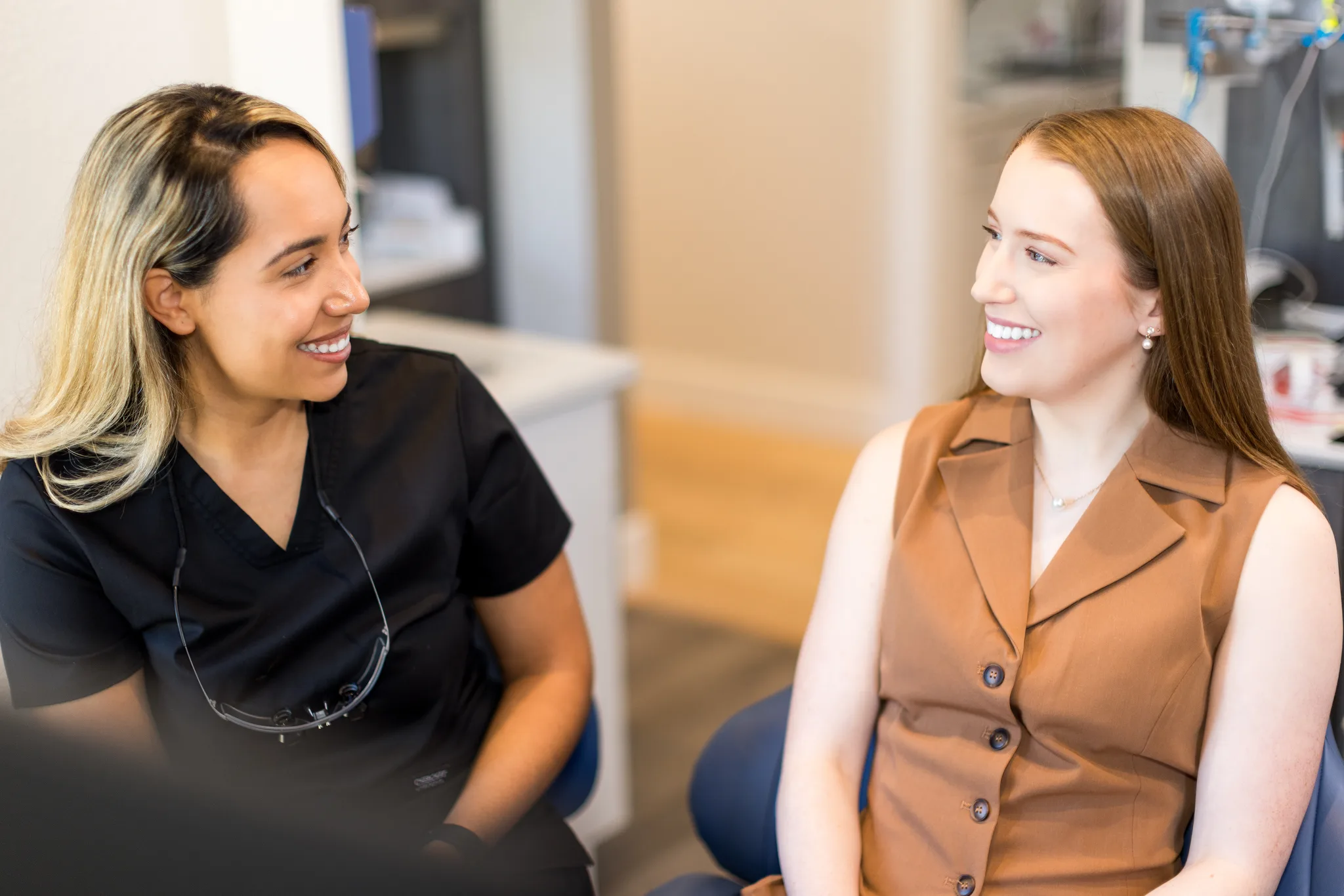 A hygienist talking with a patient chairside before a cleaning