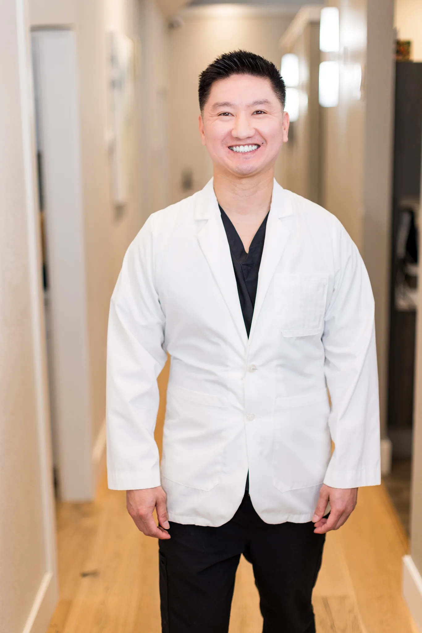 Dr. Michael Nguyen, DDS, in a white coat in the practice corridor