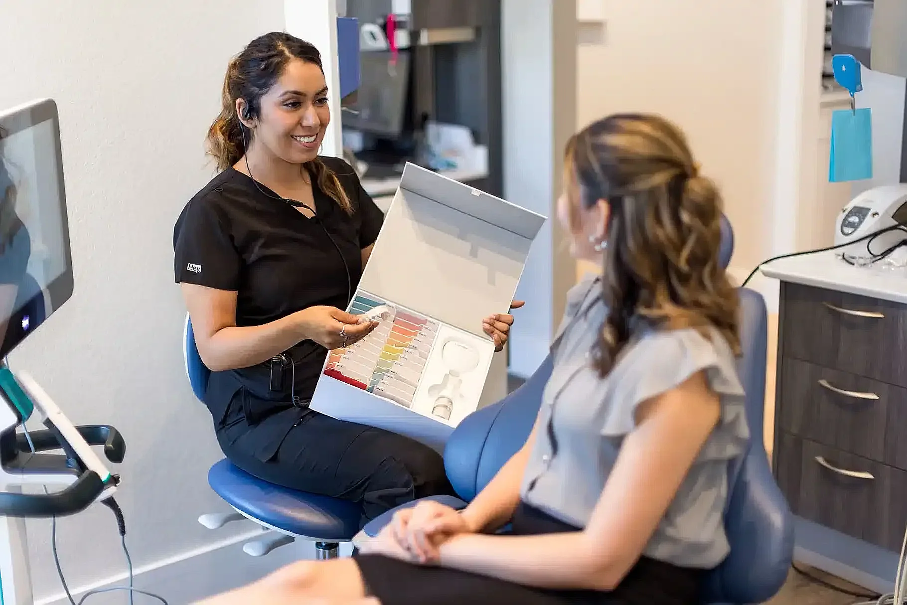 Clinician showing treatment options to a patient in the chair