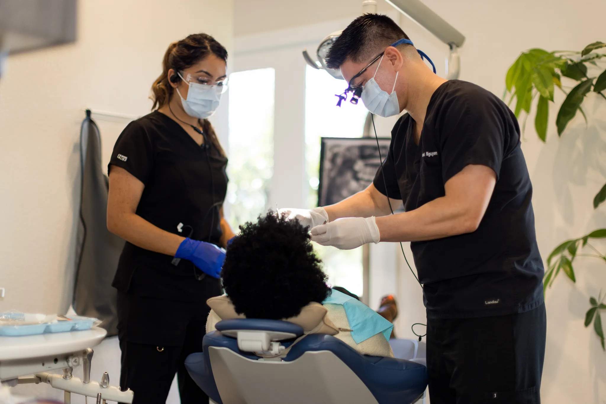 A dentist and assistant working together on a patient during a cosmetic appointment