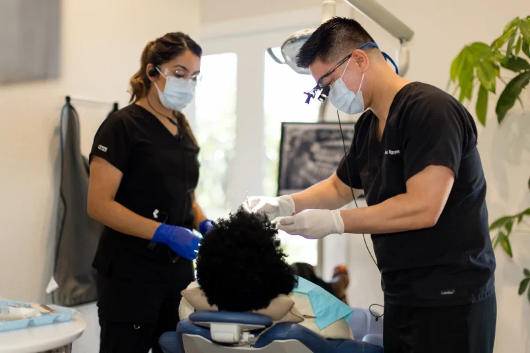 A dentist and assistant working together on a patient during a cosmetic appointment