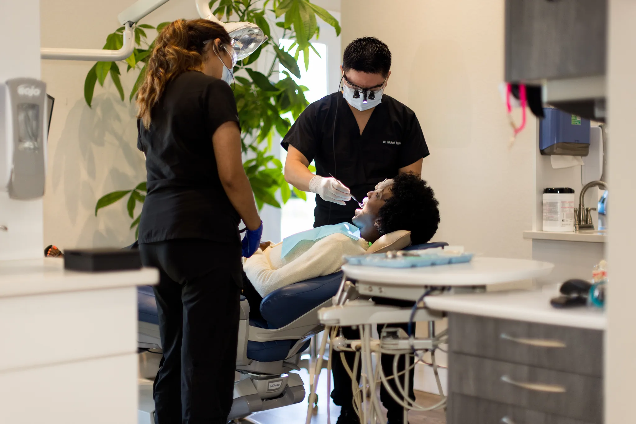 A dentist and assistant working together on a patient during a cosmetic appointment