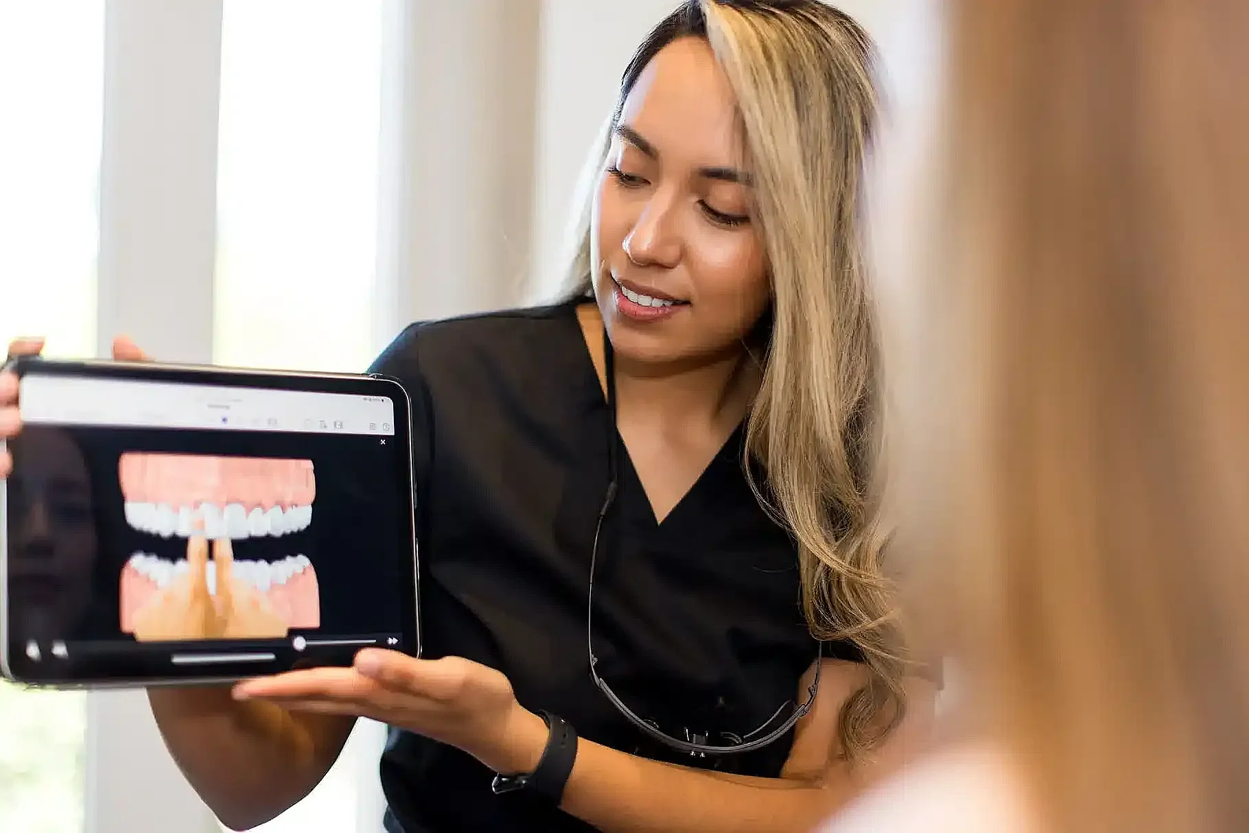Clinician showing a digital scan of a patient's teeth on a tablet