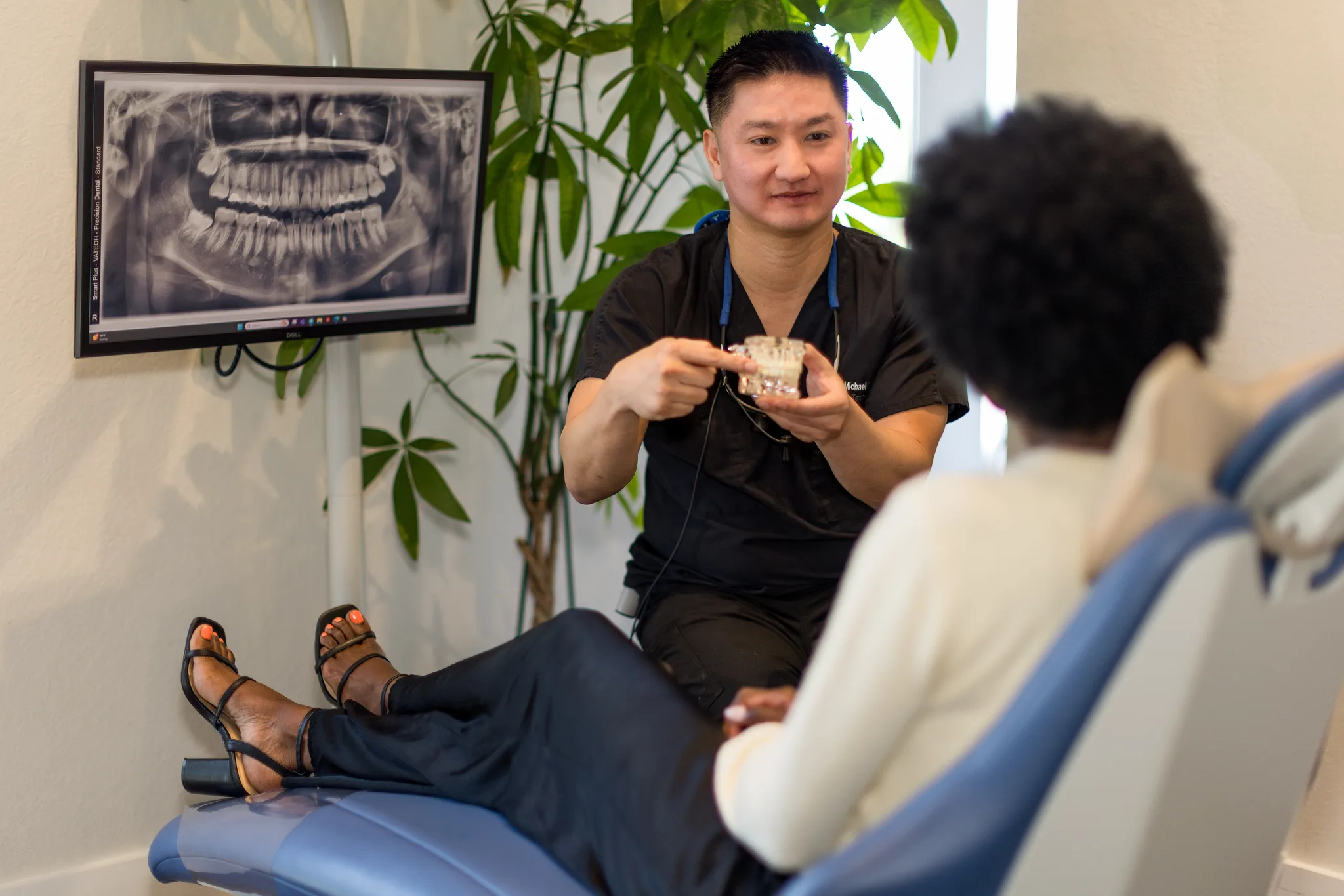 Dentist explaining a panoramic dental X-ray on the operatory screen